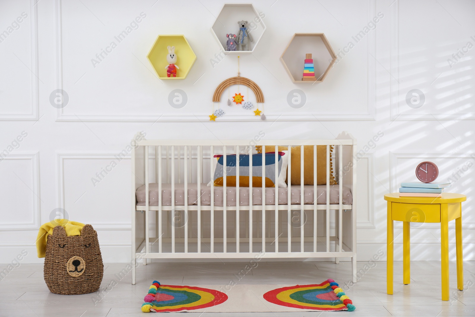 Photo of Cute baby room interior with comfortable crib and toys