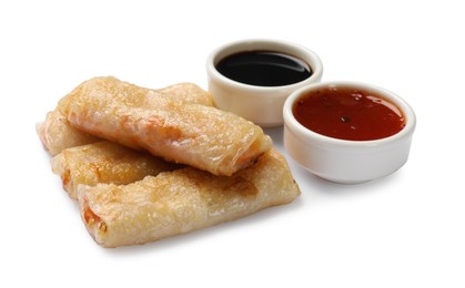 Photo of Tasty fried spring rolls and sauces isolated on white