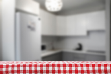 Image of Red checkered napkin on table in kitchen. Space for text