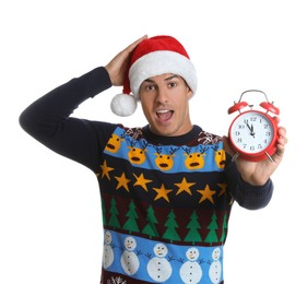 Photo of Man in Santa hat with alarm clock on white background. New Year countdown