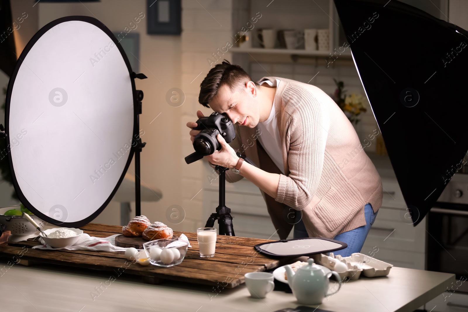 Photo of Young man taking picture of food in photo studio