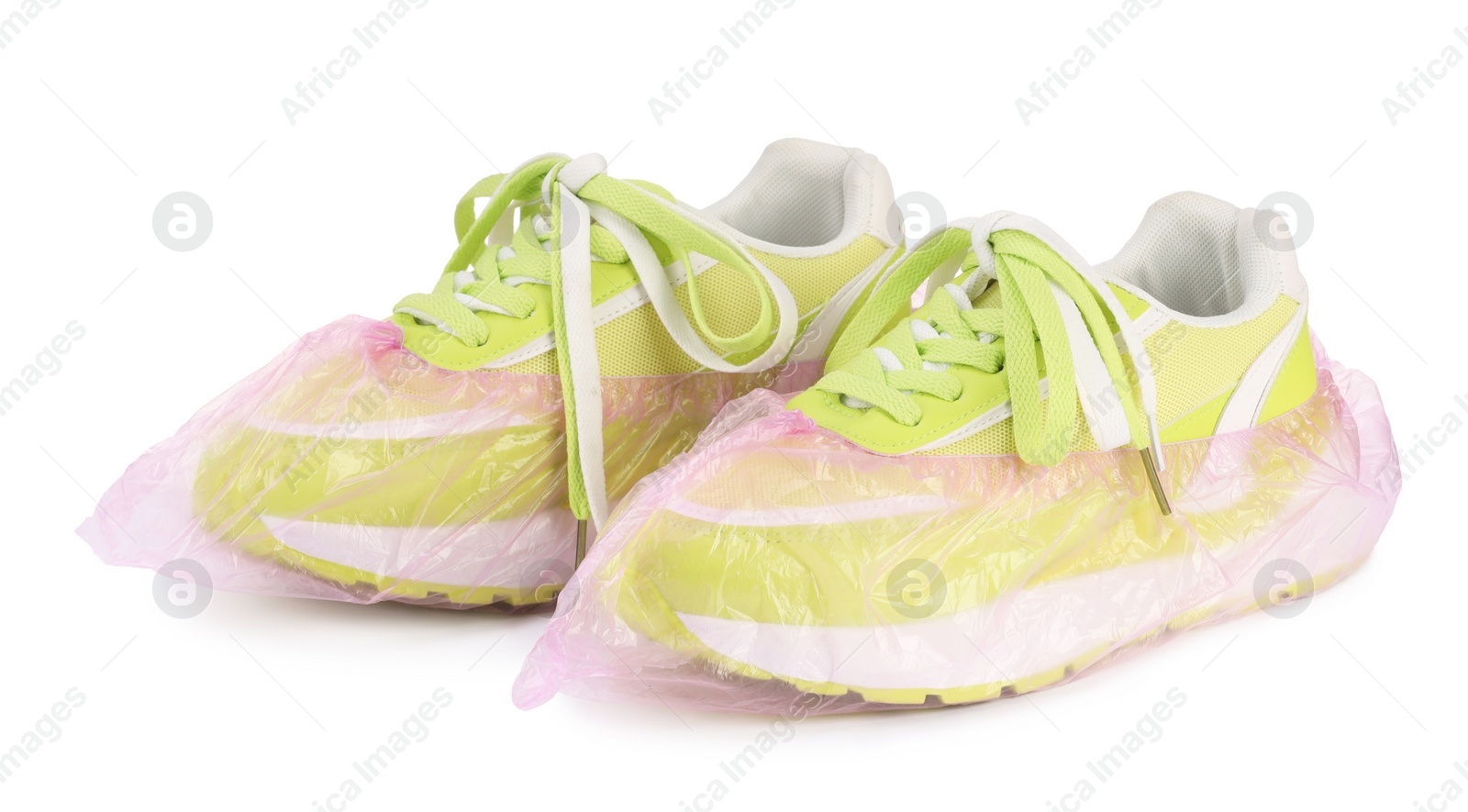 Photo of Sneakers in pink shoe covers isolated on white