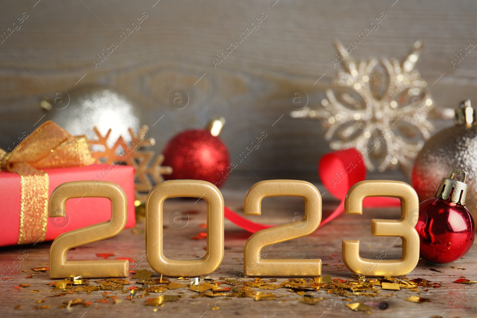 Photo of Golden number 2023 and festive decor on wooden table. Happy New Year