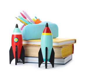 Bright toy rockets and school supplies on white background