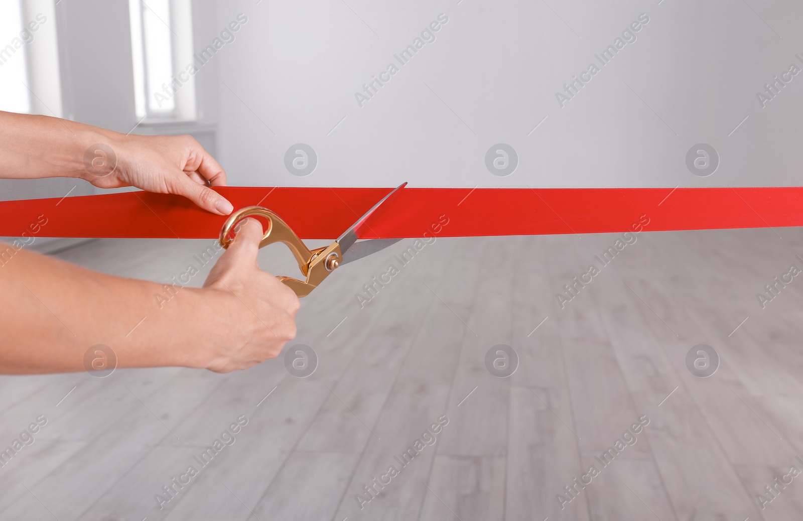 Photo of Woman cutting red ribbon on blurred background. Festive ceremony