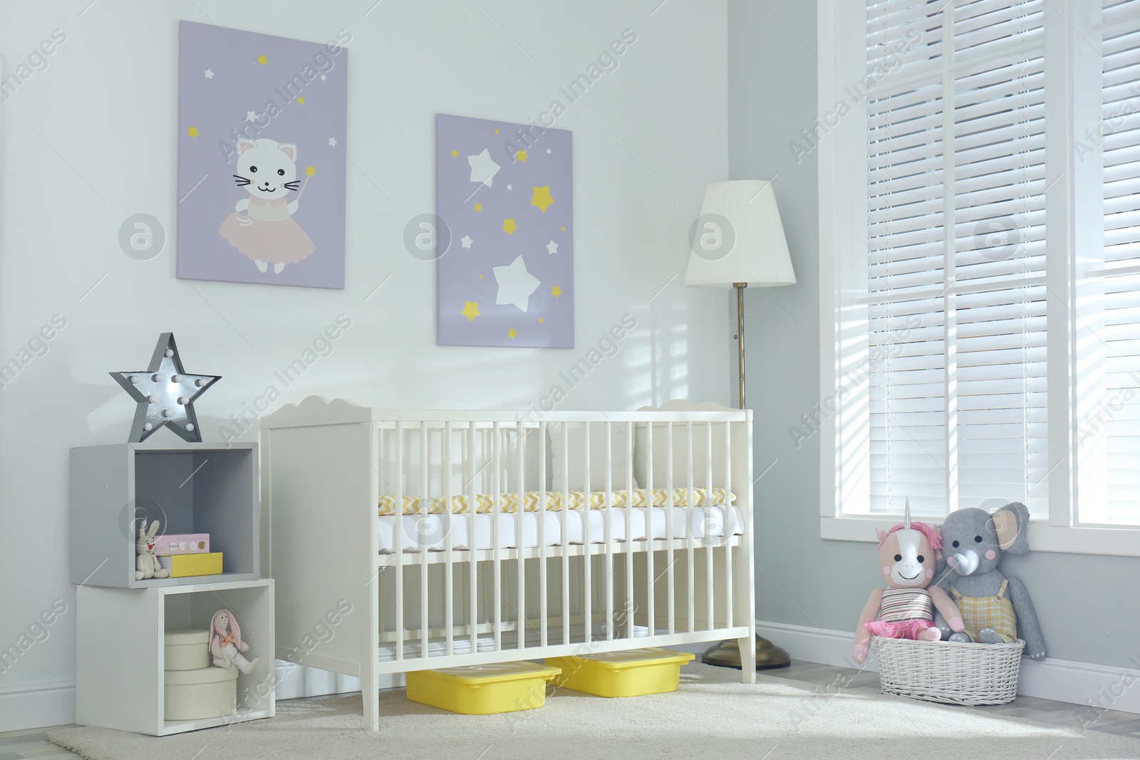 Photo of Stylish baby room interior with crib and cute pictures on wall