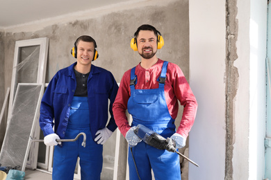 Portrait of workers with equipment indoors. Window installation