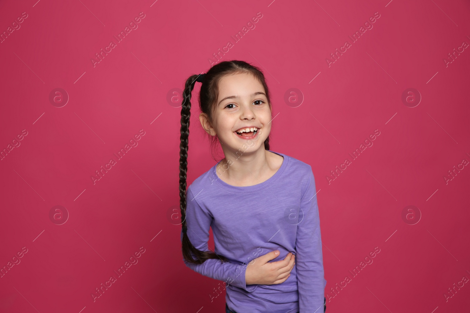 Photo of Portrait of little girl laughing on color background