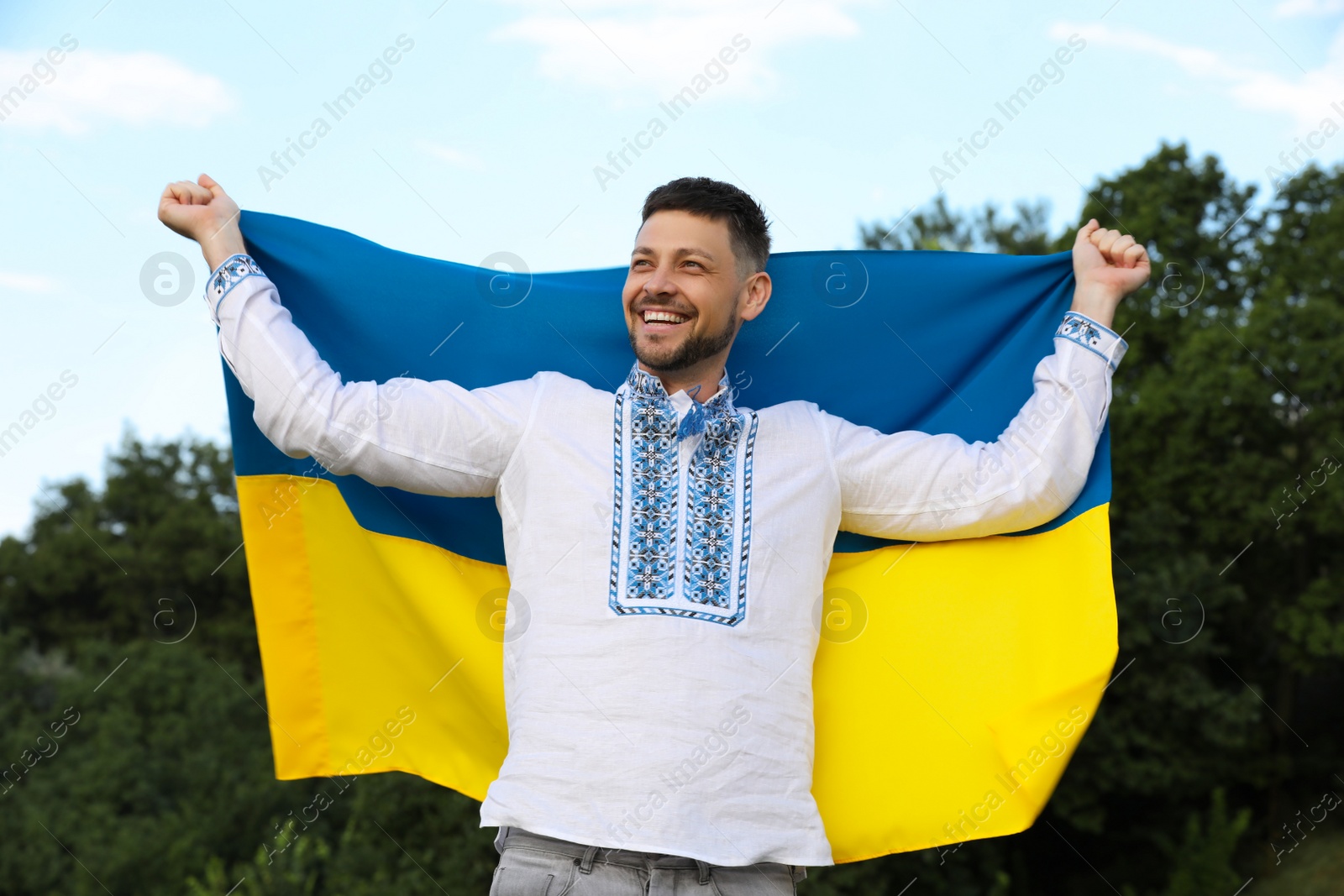 Photo of Man in vyshyvanka with flag of Ukraine outdoors