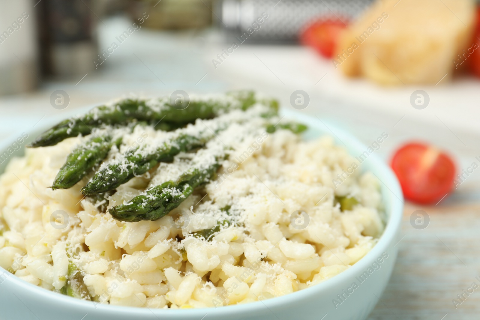 Photo of Delicious risotto with asparagus and cheese in bowl, closeup