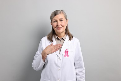 Mammologist with pink ribbon on gray background. Breast cancer awareness