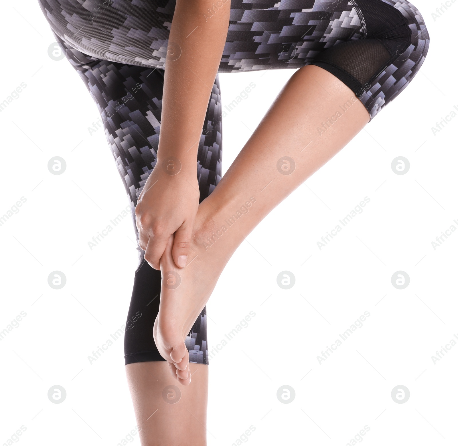 Photo of Young woman suffering from pain in foot on white background, closeup