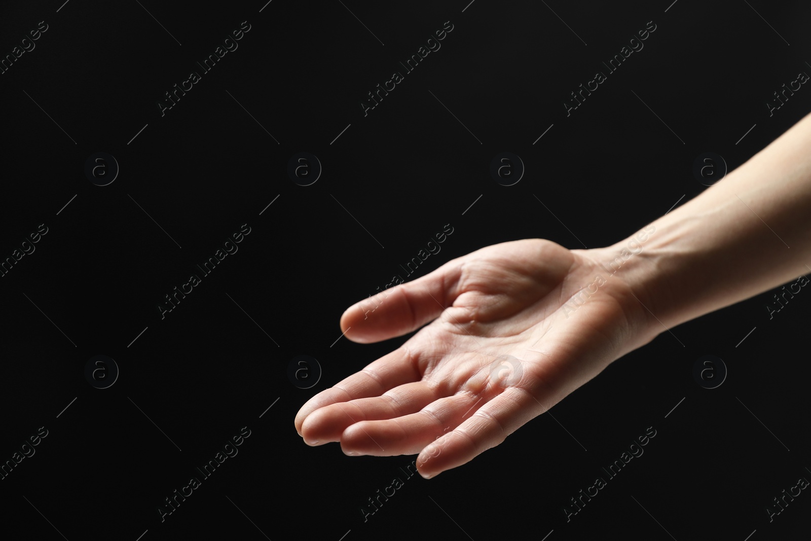 Photo of Woman holding something in hand on black background, closeup. Space for text