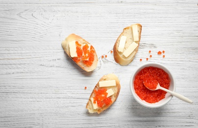 Photo of Flat lay composition with red caviar on wooden background