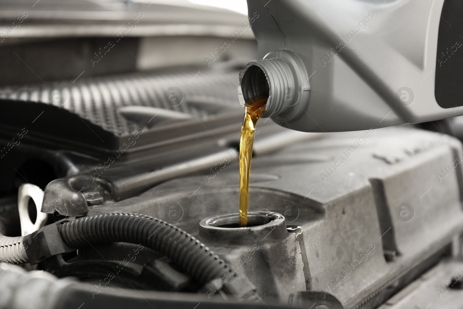 Photo of Pouring oil into car engine, closeup