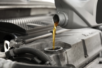 Pouring oil into car engine, closeup