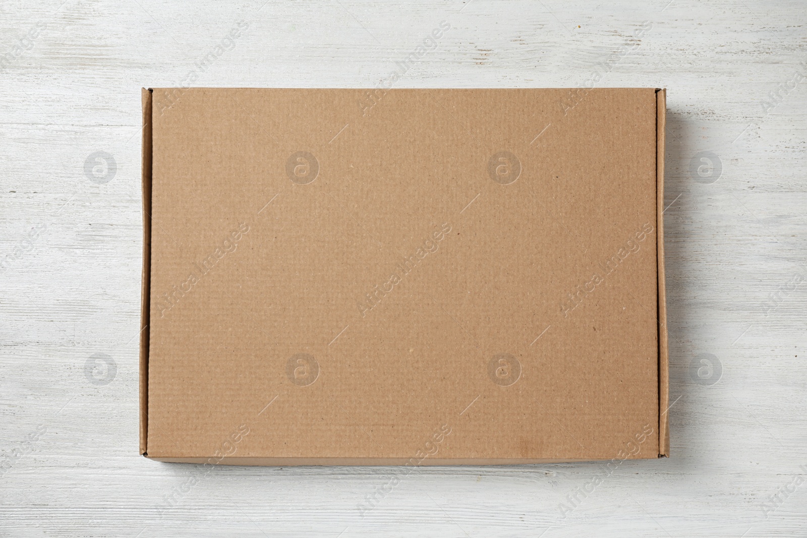 Image of Cardboard box on white wooden background, top view. Space for design