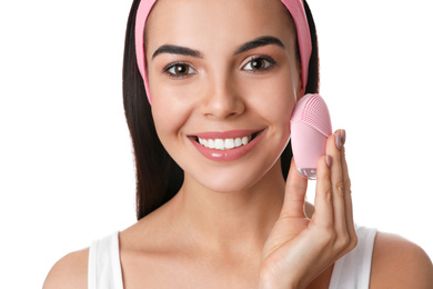 Photo of Young woman using facial cleansing brush on white background, closeup. Washing accessory