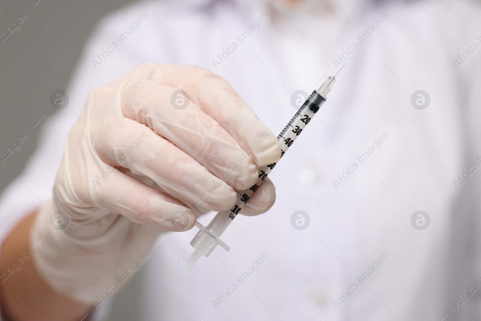 Photo of Doctor holding syringe with needle, closeup view