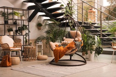 Indoor terrace interior with hanging chair and green plants