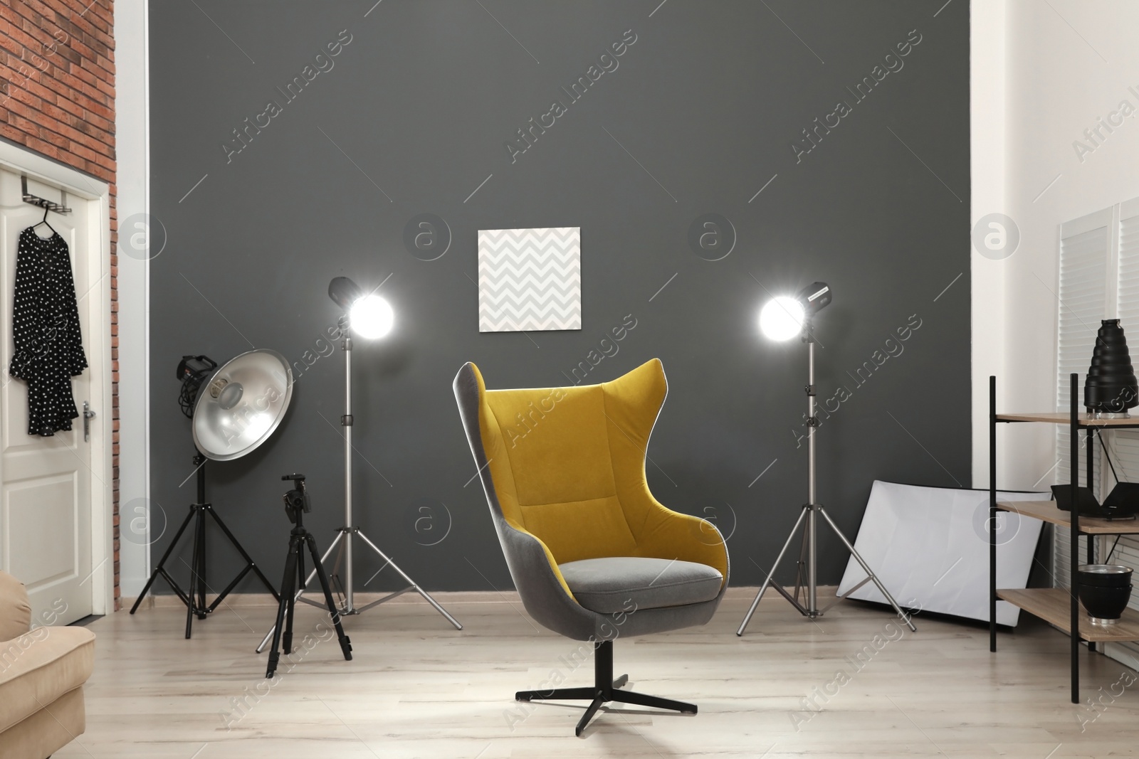 Photo of Interior of modern photo studio with armchair and professional equipment