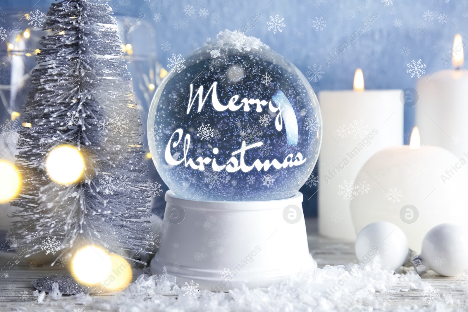 Beautiful snow globe with phrase Merry Christmas and candles on table Image of Beautiful snow globe with phrase Merry Christmas and candles on table