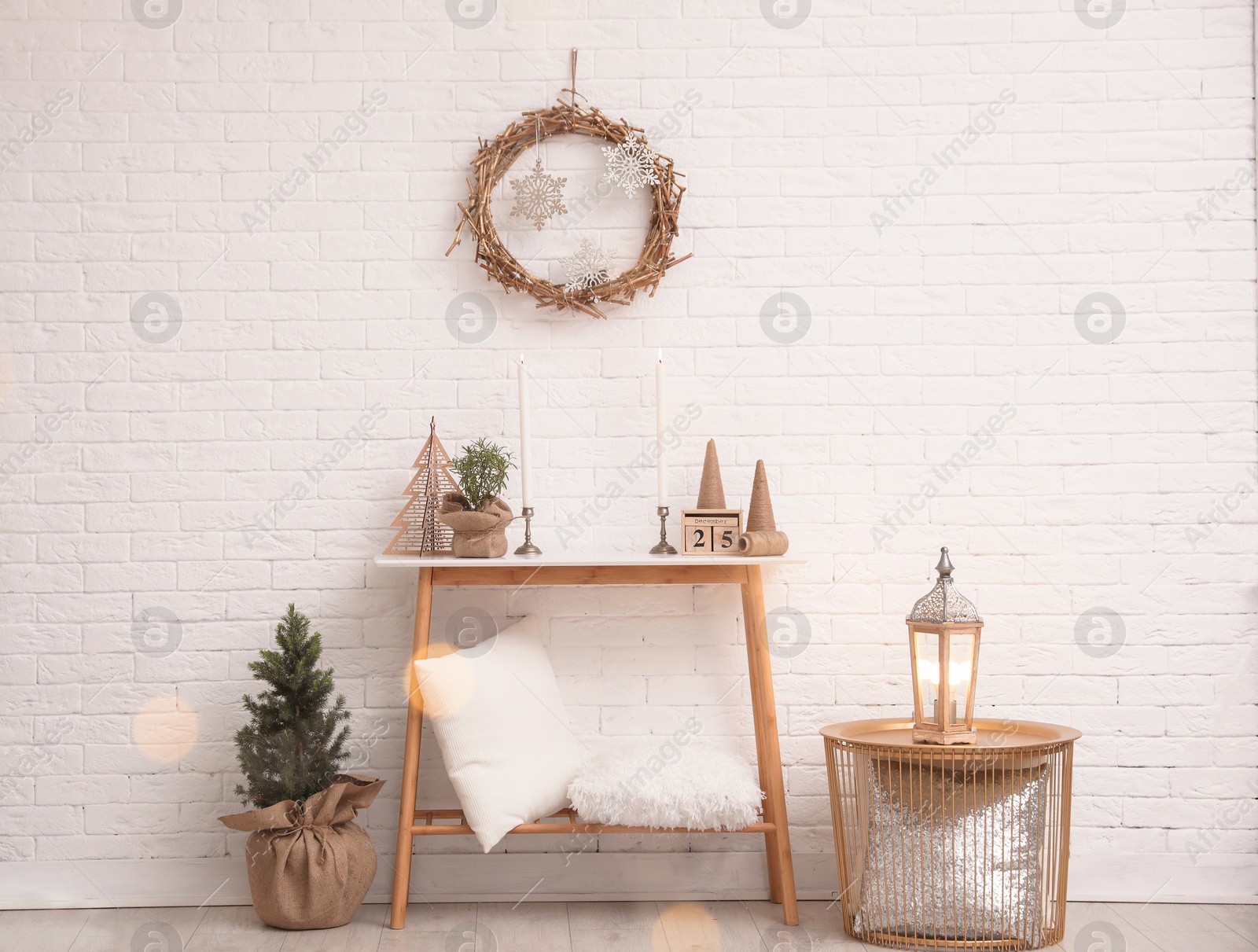 Photo of Console table with Christmas decoration near brick wall. Idea for festive interior