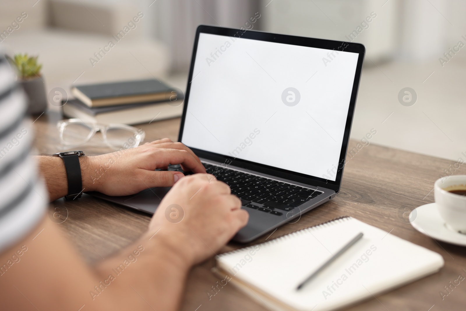 Photo of Young man watching webinar at table in room, closeup