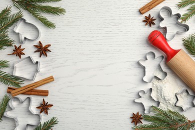 Photo of Flat lay composition with cookie cutters, fir branches and spices on white wooden table. Space for text