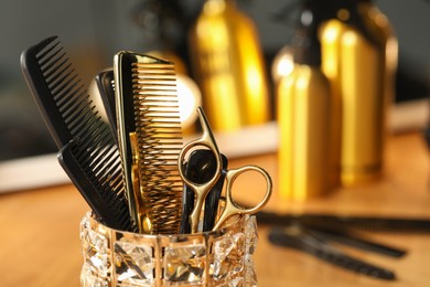 Photo of Set of hairdresser tools on table in salon, closeup