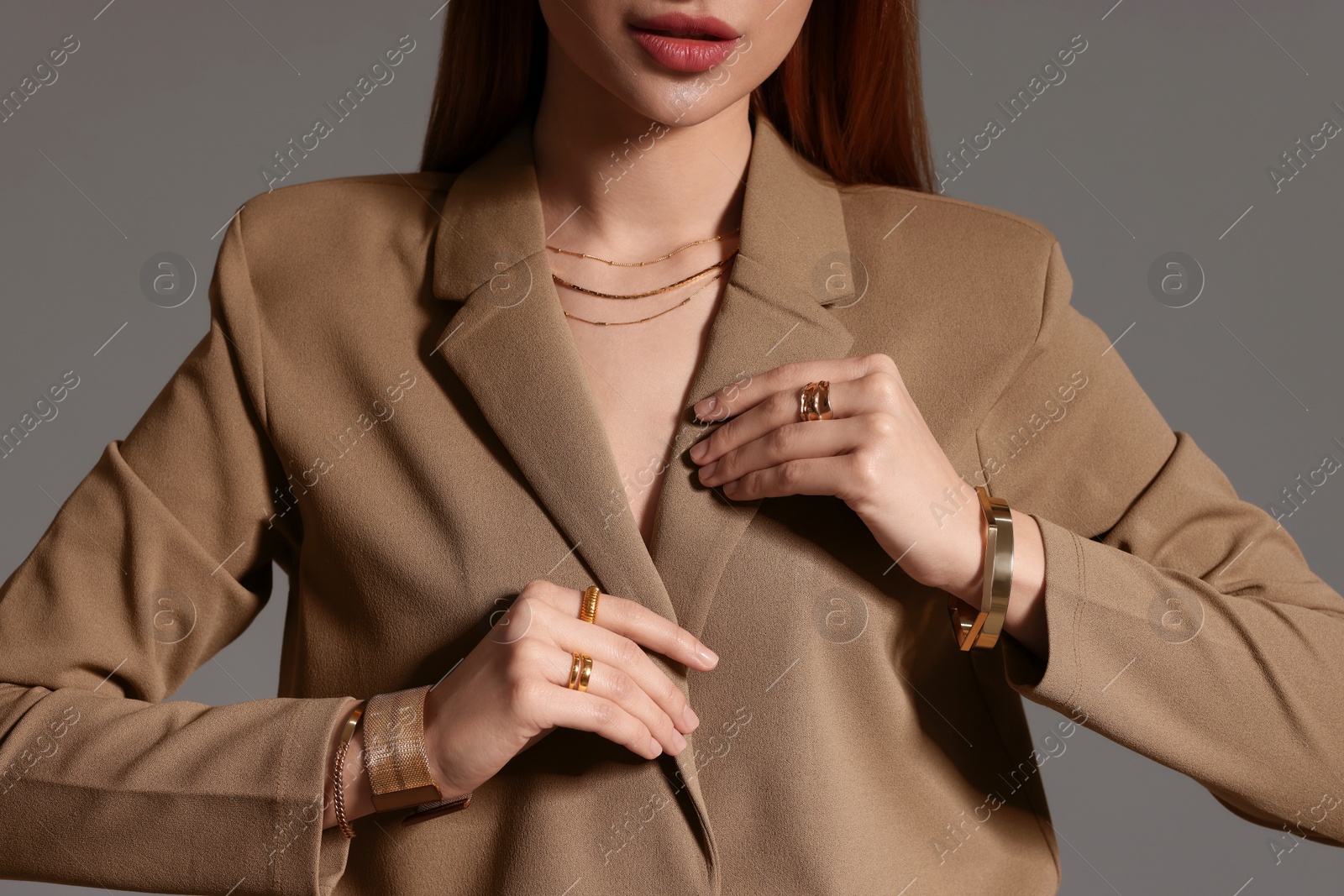 Photo of Woman with elegant jewelry on gray background, closeup