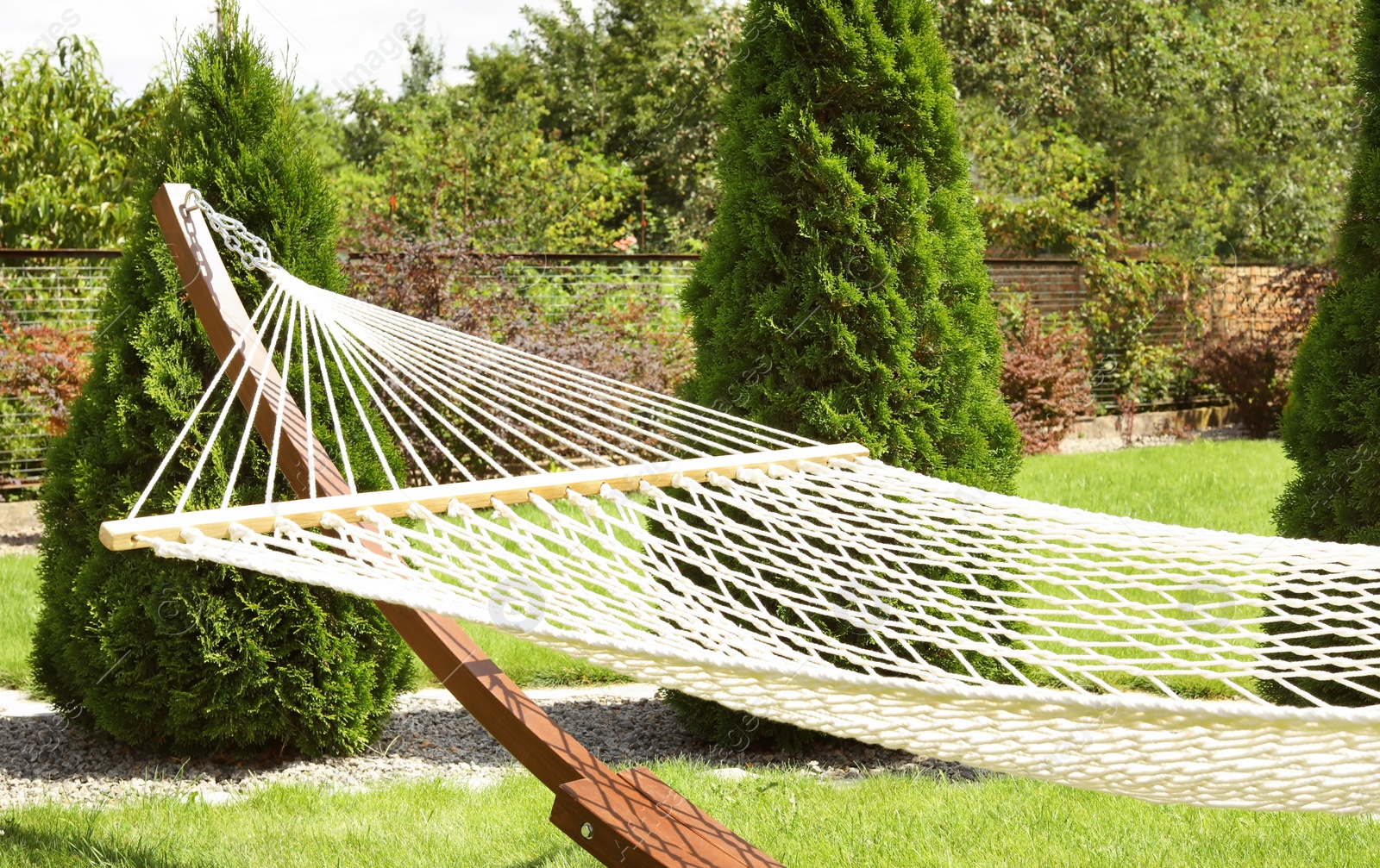 Photo of Empty comfortable hammock outdoors on sunny day