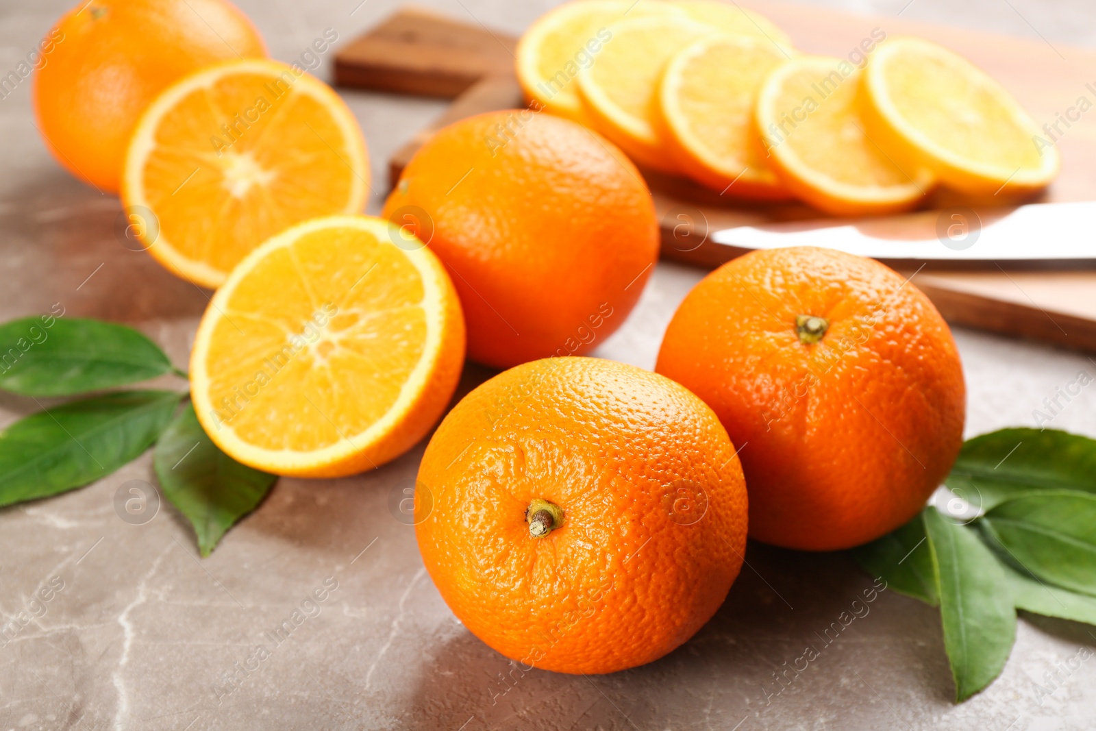 Photo of Delicious ripe oranges on grey marble table