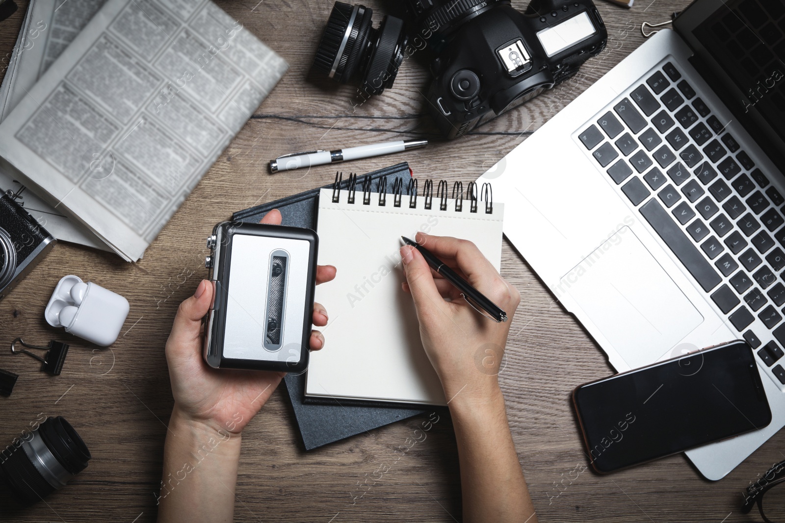 Image of Journalist with voice recorder working at wooden table, top view