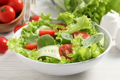 Photo of Delicious vegetable salad on white wooden table, closeup