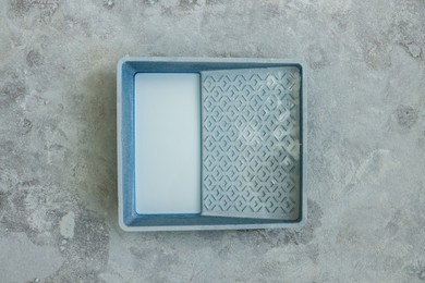 Photo of Container with white paint on floor, top view