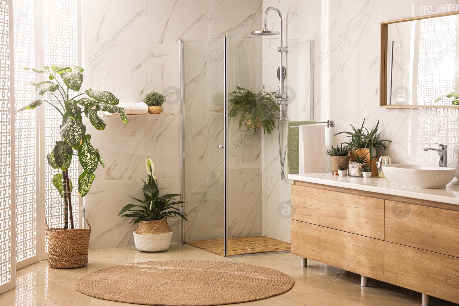 Photo of Stylish bathroom interior with countertop, shower stall and houseplants. Design idea