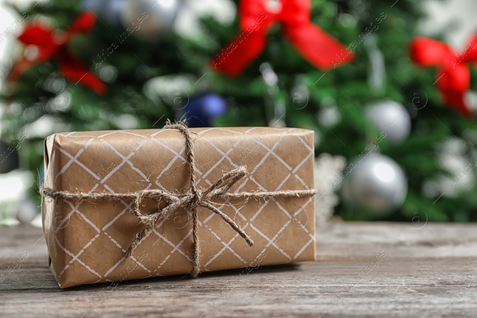 Photo of Beautiful gift box and blurred Christmas tree on background