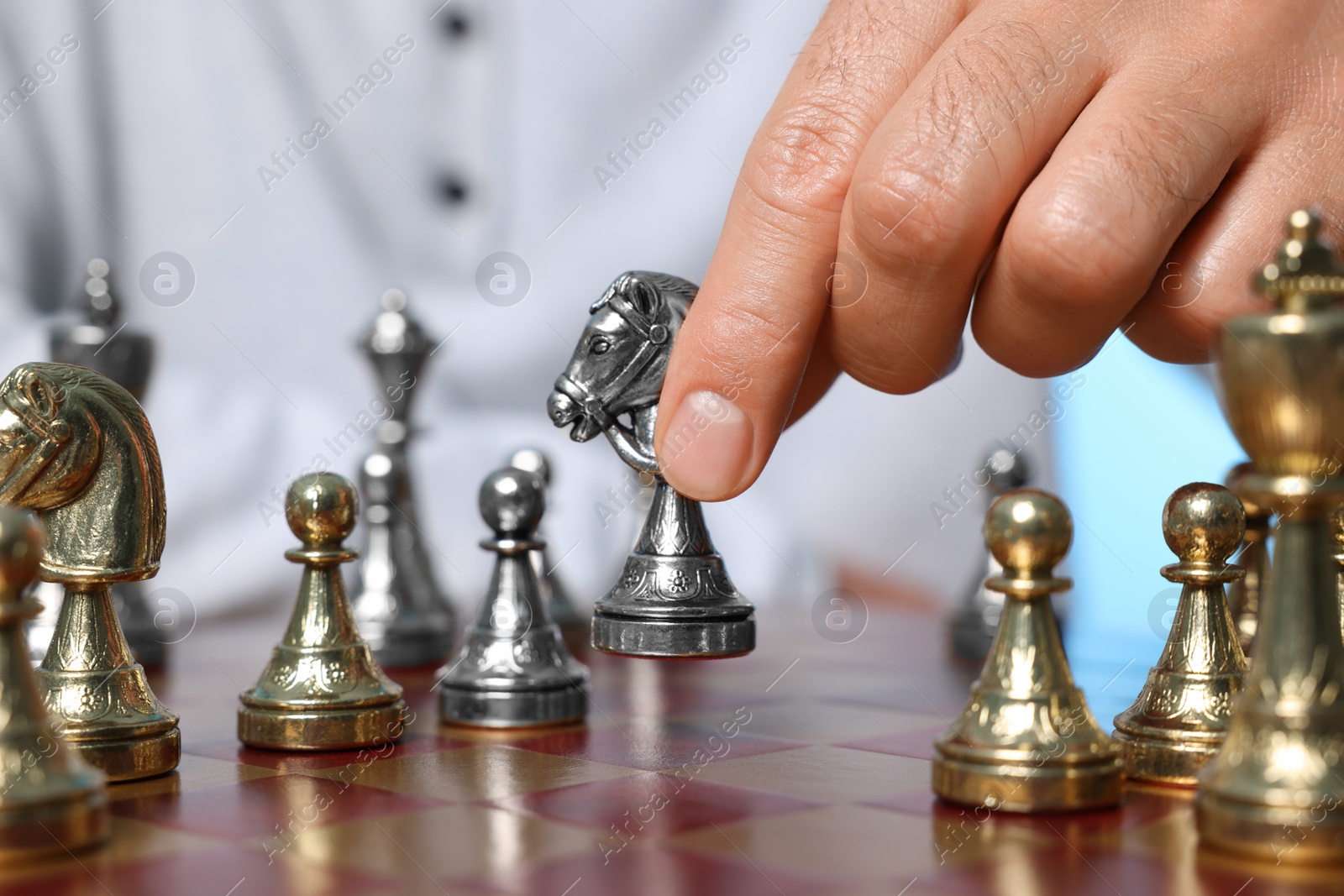 Photo of Man with knight playing chess at checkerboard, closeup