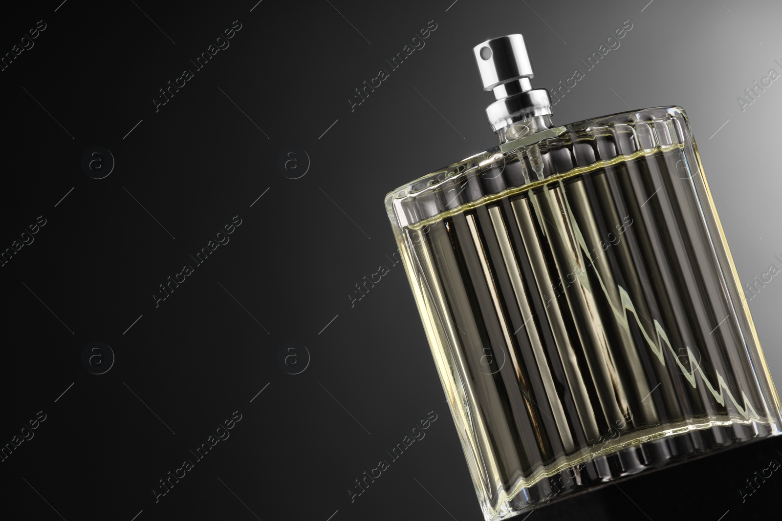 Photo of Luxury men`s perfume in bottle against grey background, space for text