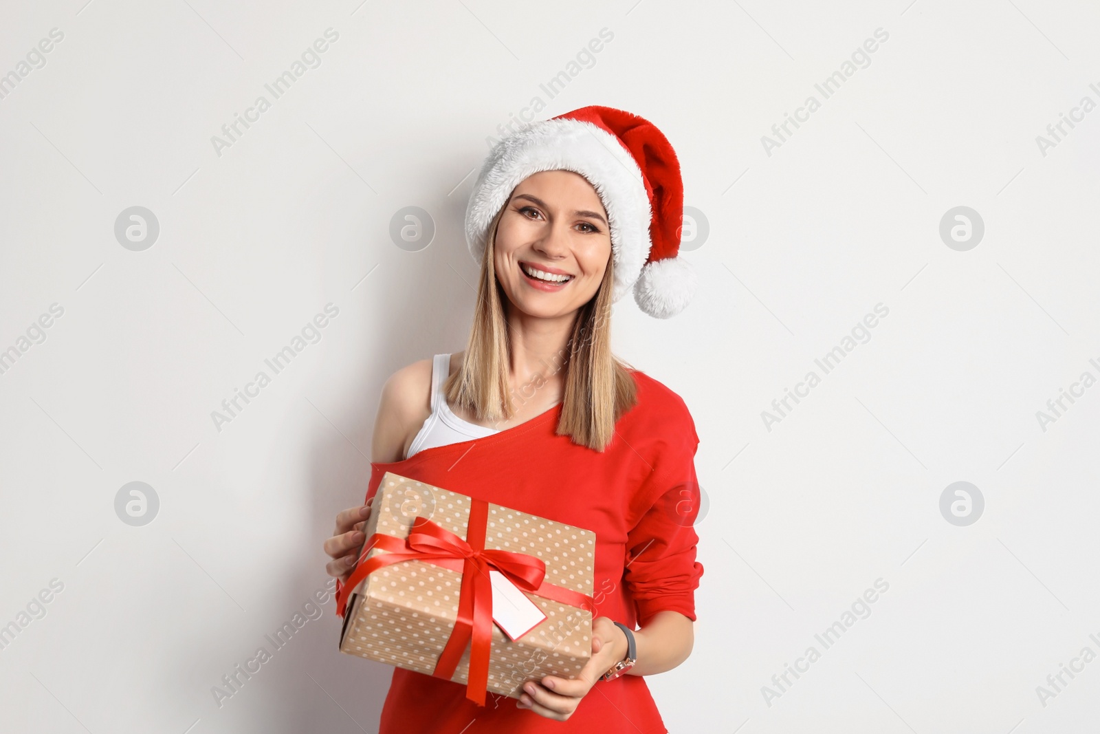 Photo of Young woman with Christmas gift on white background