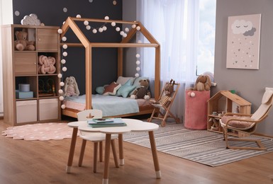 Photo of Comfortable house bed in child room. Stylish interior