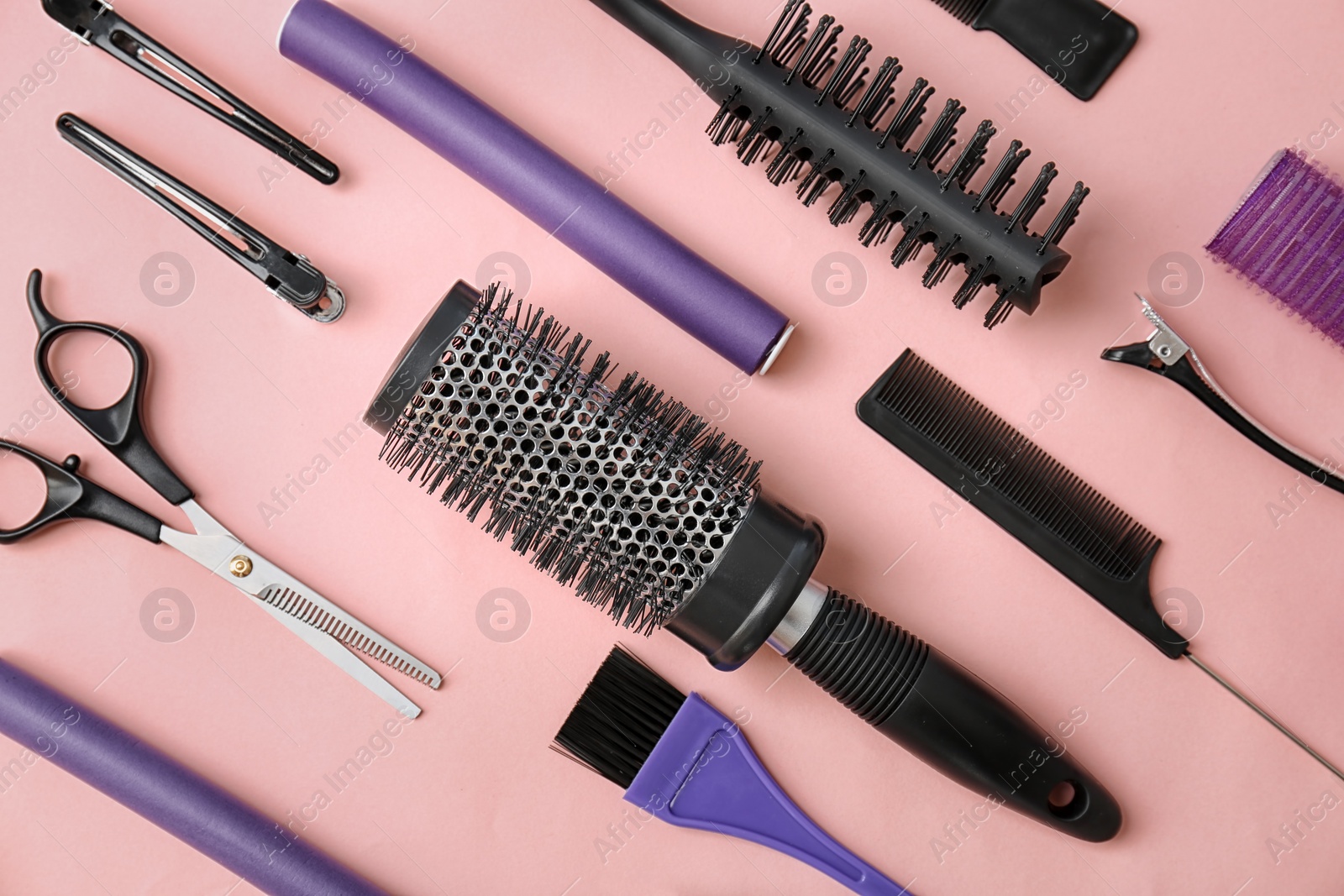 Photo of Flat lay composition with professional hairdresser tools on color background