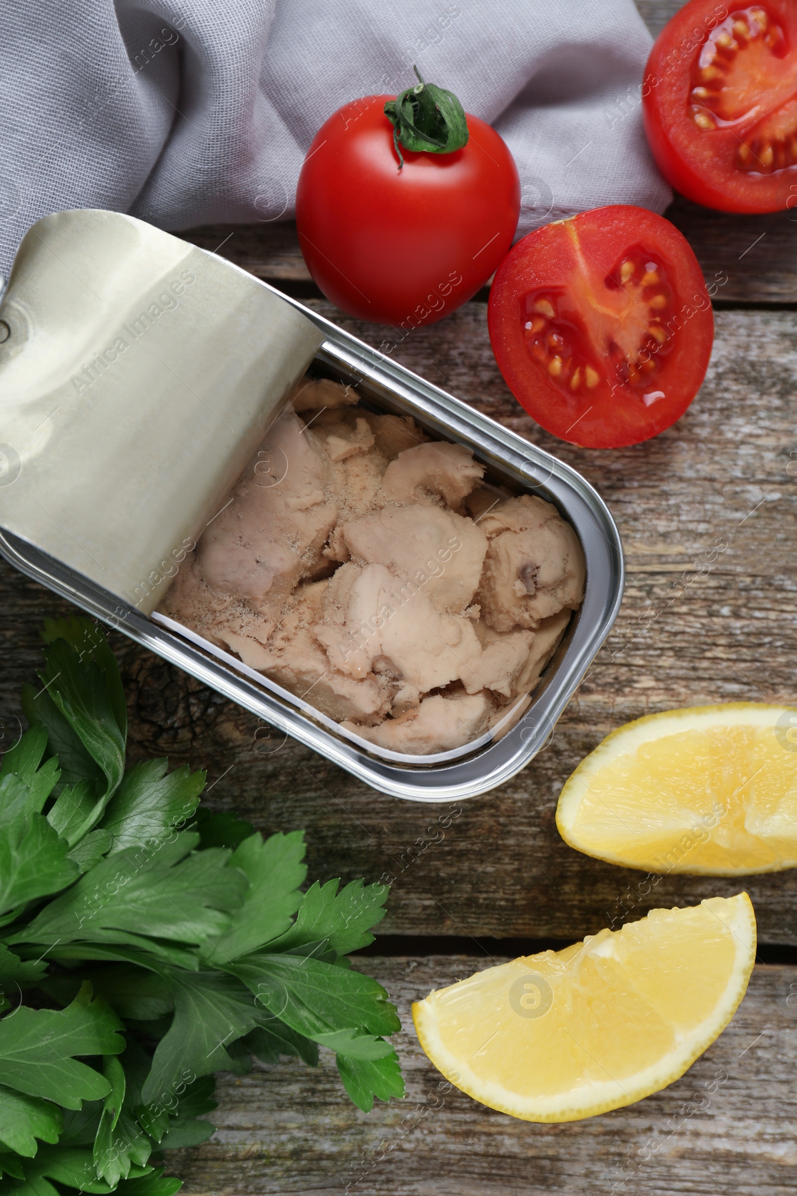 Photo of Flat lay composition with tin can of tasty cod liver and different products on wooden table