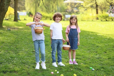 Easter celebration. Cute little children with wicker baskets and painted eggs outdoors