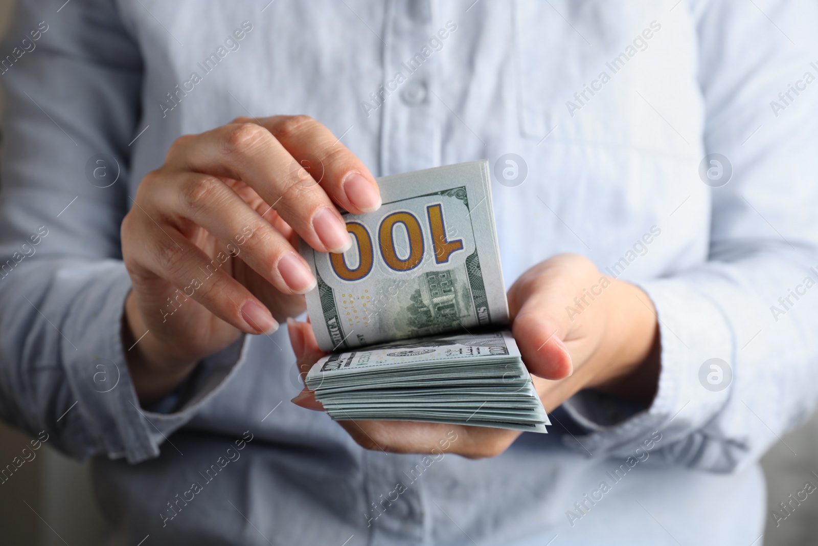 Photo of Woman holding stack of dollar banknotes, closeup