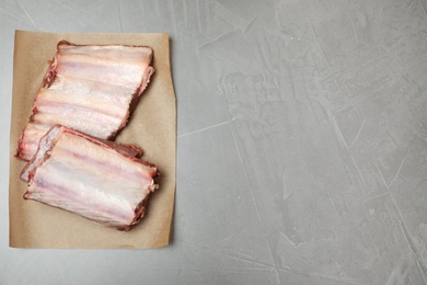 Photo of Raw ribs and space for text on gray background, top view. Fresh meat