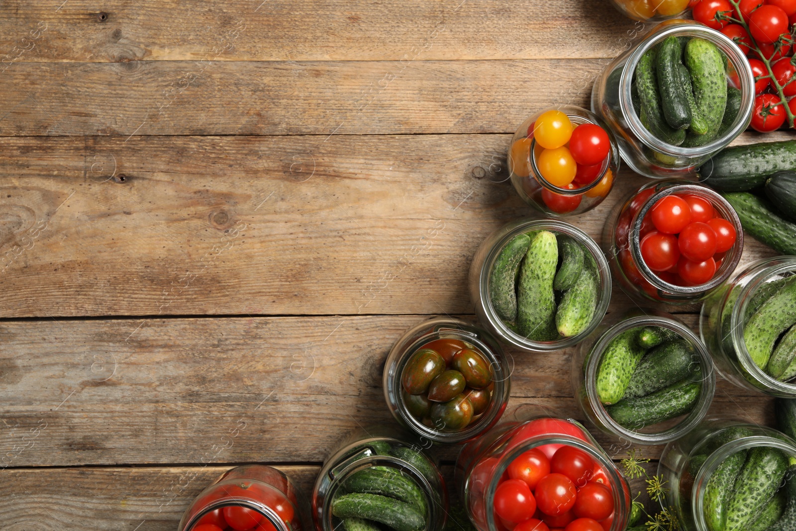 Photo of Pickling jars with fresh vegetables on wooden table, flat lay. Space for text