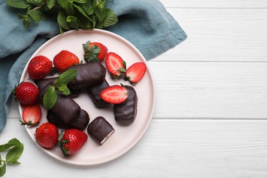 Photo of Delicious glazed curd snacks, mint leaves and fresh strawberries on white wooden table, flat lay. Space for text