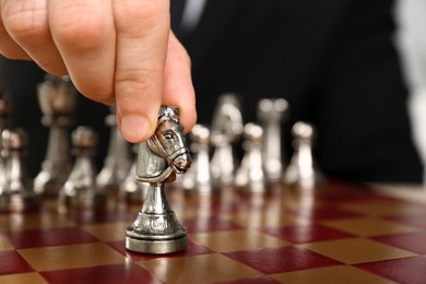 Photo of Man moving chess piece on board, closeup